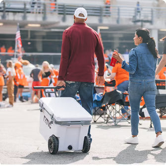 Friends pulling a cooler at a tailgate